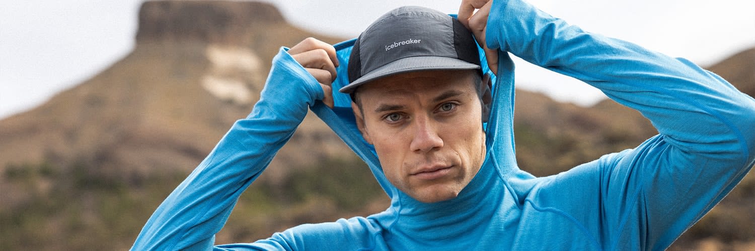 Man hiking wearing blue icebreaker merino base layer sun hoodie